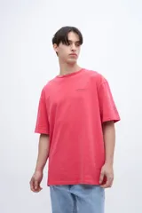 Remera roja de algodón con calce oversize, teñida en prenda con arte en el pecho y bordado en la manga.