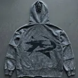 Hoodie de efecto acid wash gris oscuro, con capucha, mangas largas con costuras horizontales deshilachadas y estampa abstracta negra en la espalda.