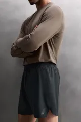 Short deportivo de entrenamiento en tejido técnico ligero y elástico, con cintura elástica ajustable mediante cordón. Presenta bolsillos frontales, un bolsillo trasero con cierre y aberturas laterales en el bajo. Incluye un pequeño logo estampado en la pernera.