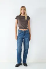 Jeans de tiro alto con corte recto, diseño clásico de cinco bolsillos, cierre frontal con cremallera y botón metálico.