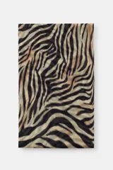 Pañuelo rectangular de modal y seda con estampado animal print tipo cebra en tonos beige, negro y marrón, con bordes deshilachados.