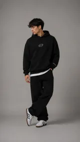 Hoodie negro de corte holgado con capucha y bolsillo frontal tipo canguro. Presenta un pequeño logo bordado en el centro del pecho y detalle en el puño de la manga.