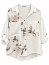Camisa de lino blanca con estampado floral en tonos rosados y verdosos, corte oversize, bolsillos delanteros en el pecho y mangas largas con presilla para arremangar.