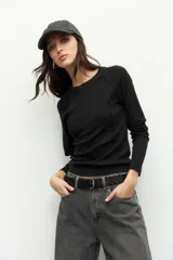 Remera gris de manga larga, corte ajustado y cuello redondo.