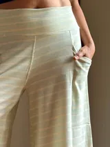Pantalón palazzo de tiro alto con estampado de rayas horizontales color crema y celeste. Confeccionado en rústico de algodón, con bolsillos laterales, elástico en la espalda y faja ancha en la cintura.