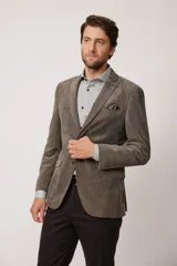 Blazer de corte slim fit confeccionado en pana de textura suave, con cierre frontal de dos botones, solapas clásicas y bolsillos laterales con solapa.