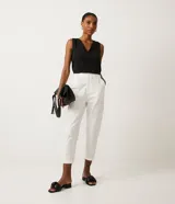 Pantalón blanco de sarga, corte baggy, con cintura media fruncida en los laterales y trabillas.