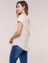 Blusa celeste de tejido calado tipo pointelle, con escote redondo, mangas cortas con dobladillo y presilla con botón, y ruedo curvo.