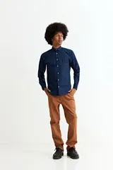 Camisa de manga larga en color beige, confeccionada en algodón, con cuello clásico y cierre frontal de botones.