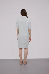 Vestido corto tipo túnica color celeste, de lino, con cuello camisero, mangas cortas y cierre frontal con botones de madera.