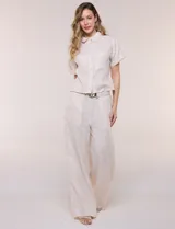 Conjunto de dos piezas confeccionado en lino, de estilo casual safari. Incluye camisa de manga corta con cuello camisero con bordado festoneado, abotonadura frontal y bolsillos en el pecho; y pantalón palazzo de tiro alto con bolsillos y cinturón con hebilla metálica dorada.