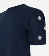 Blusa azul marino de algodón con cuello redondo y mangas cortas abullonadas con bordado floral.