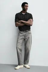 Zapatilla de cordones estilo retro, color negro con detalles en blanco y suela de goma color caramelo.