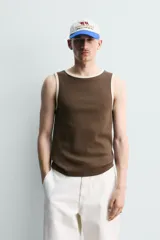 Camiseta sin mangas slim fit color crema, confeccionada en tejido de algodón elástico, con cuello redondo y ribetes en contraste color beige.
