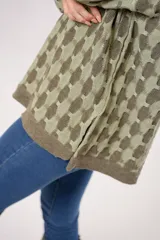 Buzo oversize de punto color verde oliva con cuello alto y diseño geométrico en dos tonos.