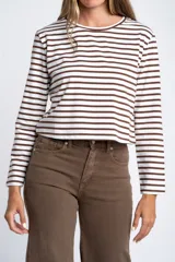 Remera de manga larga ajustada al cuerpo, con cuello redondo. Presenta un patrón de rayas horizontales anchas en color blanco y marrón oscuro.