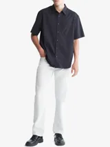 Camisa de manga corta color negro, con cuello camisero y corte holgado.