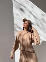 Buzo de tejido waffle color beige, con cuello redondo, mangas largas con puños y corte cropped.