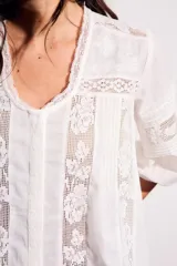 Blusa negra de algodón peinado con calce oversize, escote en V, mangas tres cuartos abullonadas y detalles de encaje y bordados en el frente y mangas.