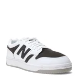 Championes urbanos New Balance modelo Court 480, con diseño inspirado en el baloncesto retro. Presentan una combinación de cuero blanco y paneles de gamuza en color gris oscuro, con el logo 'N' característico en los laterales y suela de goma.