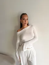 Blusa de lanilla color beige, con escote asimétrico tipo barco y mangas largas con terminación acampanada.