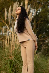 Buzo color beige de cuello alto y mangas abullonadas.