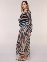 Vestido largo de playa confeccionado en gasa translúcida con estampado animal print en tonos beige, marrón y negro, de corte recto y holgado, con escote en V pronunciado, lazo frontal, mangas largas amplias con puños elastizados y tajos laterales en el ruedo.