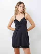 Chemise negra con breteles finos regulables y apliques de encaje en escote y ruedo.