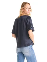 Blusa de satén color azul marino con escote en V y mangas cortas con tres capas de volados superpuestos.