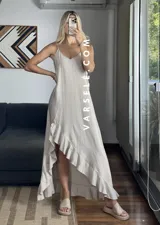 Vestido largo color marrón con breteles finos y volados asimétricos en el ruedo.