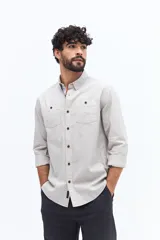 Camisa de gabardina azul marino con efecto stone wash, doble bolsillo frontal con solapa y botón, y fit regular.