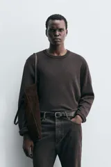 Jersey de corte relajado con cuello redondo y manga larga, confeccionado en tejido jacquard con diseño de rayas horizontales finas.