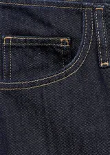 Jean de tiro medio con diseño wide leg, confeccionado en tejido de algodón estilo vaquero. Cuenta con cinco bolsillos y cierre frontal oculto con botón, gancho y cremallera.