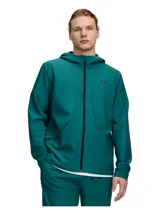 Campera deportiva Under Armour con capucha, de color verde oscuro, confeccionada con tecnología UA Storm que repele el agua y tejido elástico. Cuenta con cierre frontal y bolsillos laterales con cremallera.