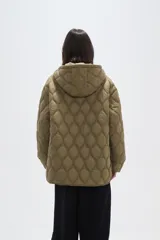 Campera acolchada de color negro con diseño capitoneado de ondas, manga larga, capucha integrada y cierre frontal con botones a presión.