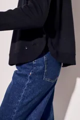 Sweater de tejido de punto en color negro, con corte oversize, cuello redondo y mangas largas con puños acanalados.