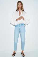 Jeans de tiro alto con corte mom fit, cinco bolsillos y cierre frontal con cremallera y botón.