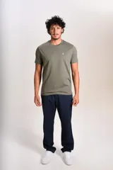 Remera de manga corta con cuello redondo, confeccionada en tejido de punto liso color verde militar. Presenta el logo de la marca Original Penguin bordado en pequeño en el pecho.