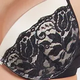 Soutien con aro y copa color crudo, con detalles de puntilla negra en la copa. Espalda de tela con fibra LYCRA® color negro. Breteles regulables y ganchos reforzados.