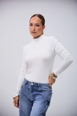 Polera básica de manga larga color crudo, con cuello alto y tejido acanalado.