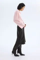 Camisa oversize de manga larga en mezcla de viscosa, color rosado claro. Cuenta con cuello camisero clásico, cierre frontal con botonadura oculta y canesú en la espalda. Presenta hombros caídos, puños anchos y bajo recto con aberturas laterales.
