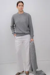 Sweater gris de tejido de punto, con cuello redondo y mangas largas.