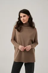 Polera de punto color marrón, de diseño holgado con mangas murciélago y cuello alto vuelto.
