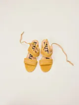 Sandalias de gamuza color bordó con taco bloque de charol, tiras con pespuntes artesanales en cuero y tira fina ajustable al tobillo.