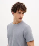 Remera masculina de corte regular, color beige melange, con cuello redondo, manga corta y textura horizontal.