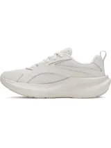 Championes Under Armour modelo W Assert 11, de color blanco y tiza, diseñados para running y entrenamiento. Presentan una capellada de malla transpirable con superposiciones de cuero resistente, mediasuela con amortiguación Charged+ Cushioning y suela exterior de goma.