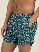 Short de baño con estampado floral pixelado en tonos azul, celeste y negro. Cuenta con cintura elástica ajustable, dos bolsillos laterales y un bolsillo trasero con cierre.