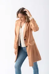 Blazer beige de poliéster con corte entallado, terminaciones impecables, bolsillos funcionales y forro interior suave.