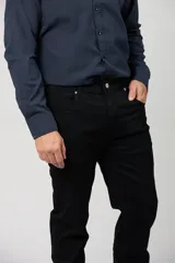 Jean clásico de corte recto en color negro, confeccionado en 100% algodón, con diseño de cinco bolsillos y cierre frontal con botón y cremallera.