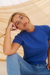 Polera de tejido de punto color celeste claro, de manga corta y cuello alto tipo mock neck.